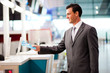 Photo: handsome businessman handing over air ticket at check in handsome businessman handing over air ticket at check in