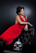 Girl red dress with leather chair and skull