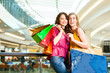 Two women shopping with bags in mall
