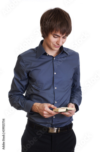 Photo: Happy young businessman read something in small book Happy young businessman read something in small book