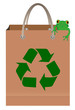 Green tree frog sitting on paper bag with recycle symbol