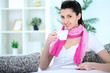 Beauty lady sitting on sofa and drinking coffee