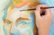 man hand painting multicolored abstract portrait of male