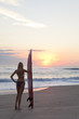 Woman Surfer In Bikini With Surfboard At Sunset Beach