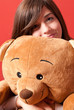 Photo: Young woman embracing teddy bear sitting close-up Young woman embracing teddy bear sitting close-up