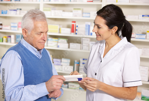 Photo: American pharmacist serving senior man in pharmacy American pharmacist serving senior man in pharmacy