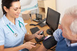 British nurse taking senior man's blood pressure