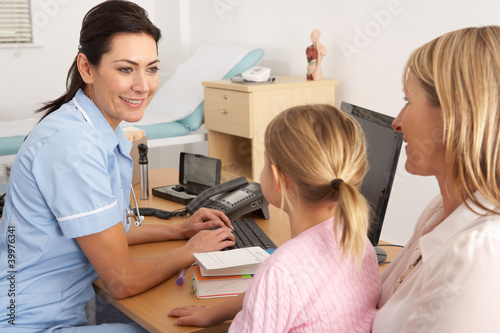 Photo: British nurse talking to young child and mother British nurse talking to young child and mother