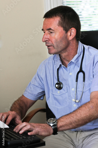 Photo: Doctor Typing On A Computer Doctor Typing On A Computer