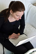 Woman Looking At White Netbook While Sitting On A Couch