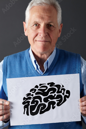 Photo: Senior man holding ink drawing of brain Senior man holding ink drawing of brain