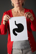 Senior woman holding ink drawing of stomach