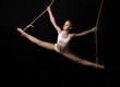 Foto: Young woman gymnast. On black background Young woman gymnast. On black background