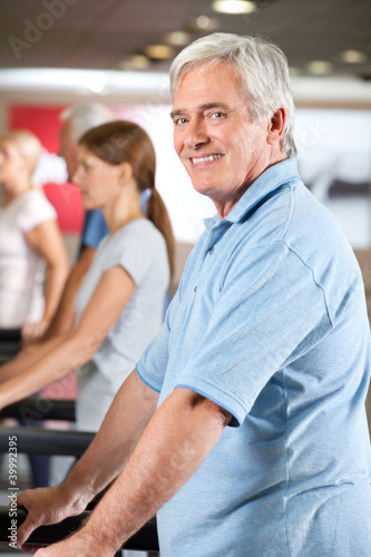 Photo: Mann auf Laufband im Fitnesscenter Mann auf Laufband im Fitnesscenter