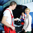 Mechanics working on engine bay, customer in front