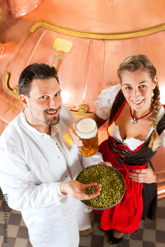 Photo: Braumeister und Frau mit Bier in Brauerei Braumeister und Frau mit Bier in Brauerei