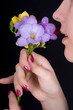 Woman sniffing flowers, freesia