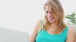 Woman laughing while using her laptop