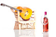 Rose wine bottle and glass with a guitar on background