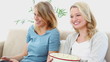 Two blonde women eating popcorn