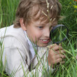 boy with magnifying glass outdoors