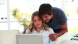 Couple talking in front of a laptop