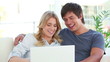 Happy couple talking in front of a laptop