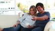 Smiling couple looking at the television