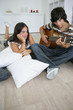 teenage lost in admiration for boyfriend playing guitar