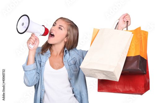 Photo: woman shouting into a megaphone and holding up store bags woman shouting into a megaphone and holding up store bags