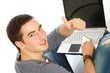 A young guy sitting on the floor with a laptop, back-view