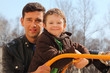 Foto: happy father and little son wearing in jacket at playground happy father and little son wearing in jacket at playground