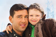 Foto: happy father and his little son wearing in jacket hug outdoor happy father and his little son wearing in jacket hug outdoor