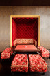 Beautiful red couch in niche, table and stools in restaurant
