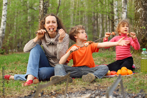 Foto: Mother and children finish to eat grilled shish kebab Mother and children finish to eat grilled shish kebab