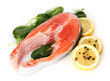 Red fish with lemon, green leaves and pepper isolated on white.