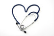 A stethoscope lying in a shape of a heart on white background