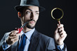 Detective with magnifying glass and pipe