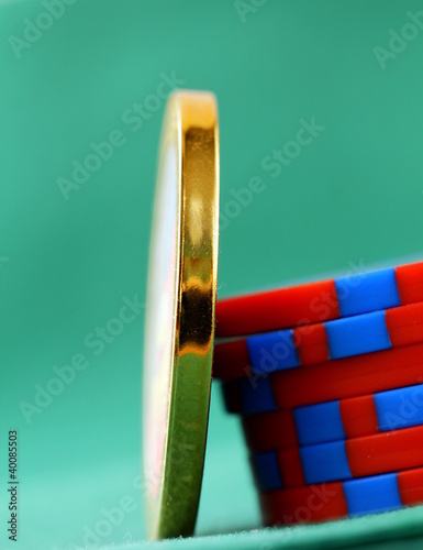 Photo: gambling chips and a gold chip on a green background gambling chips and a gold chip on a green background