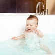 Cute baby splashing water while taking a bath