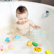 Cute smiling baby splashing water while taking a bath