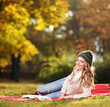 Young smiling female reading a book in a park