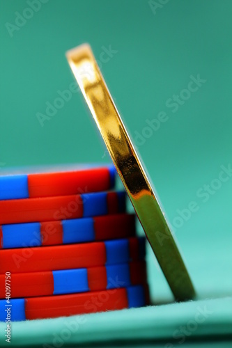Photo: gambling chips and a gold chip on a green background gambling chips and a gold chip on a green background