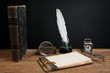 Antique book, quill, inkwell, magnifying glass, notepad, clock
