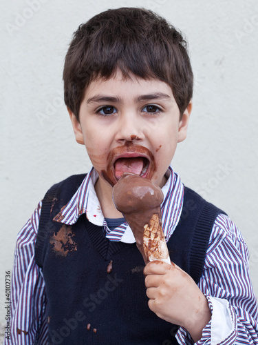 Photo: bambino che mangia gelato al cioccolato sporco bambino che mangia gelato al cioccolato sporco