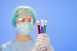 Medical test tube samples in doctor's hand on blue background