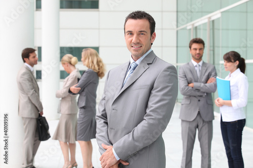 Photo: Group of business people stood outside building Group of business people stood outside building