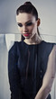 Young beautiful brunette pose in a fashionable dress.