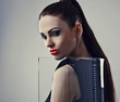 Young beautiful brunette pose in a fashionable dress.