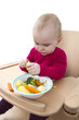 Foto: young child eating in high chair young child eating in high chair